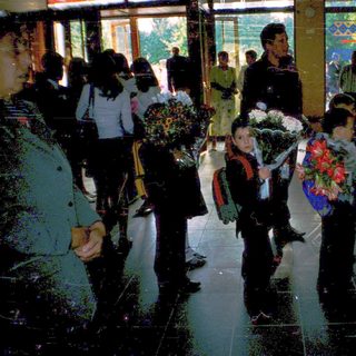 First-day-of-school gathering with students holding flowers.