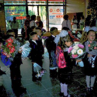 First-day-of-school celebration with students holding flowers.