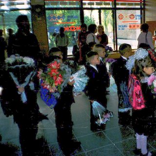 First-day-of-school celebration with students holding flowers.