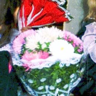 First-day-of-school ceremony with students holding flowers.