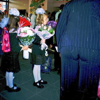 First-day-of-school ceremony with students holding flowers.