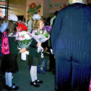 First-day-of-school ceremony with students holding flowers.
