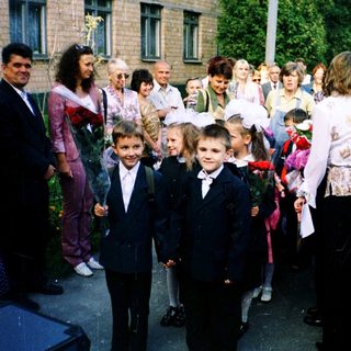 First-day-of-school ceremony with children in formal attire.