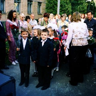 First-day-of-school ceremony with children in formal attire.