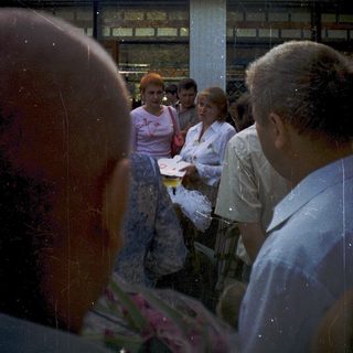 Group of people gathered outdoors, possibly at a hospital.