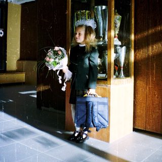 Young girl in bridal gown holding bouquet.