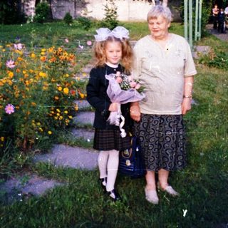A woman and young girl holding flowers in a garden.
