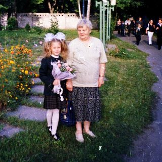 A woman and young girl holding flowers in a garden.
