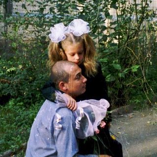 Two children hugging outside an old building.