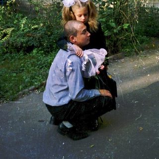 Two children hugging outside an old building.