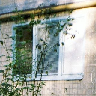 Two children hugging outside an old building.
