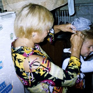 Woman drying child's hair in kitchen.