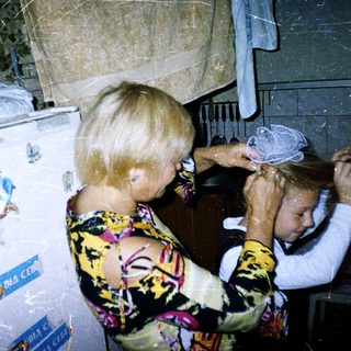 Woman drying child's hair in kitchen.