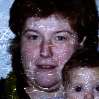 A woman holding a baby indoors.