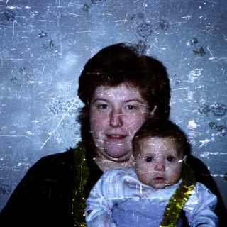 A woman holding a baby indoors.