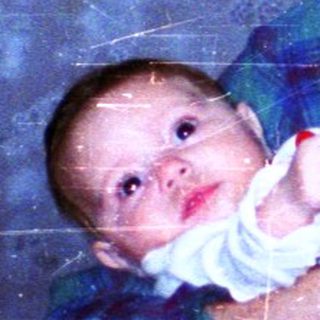 A man holding a baby indoors.