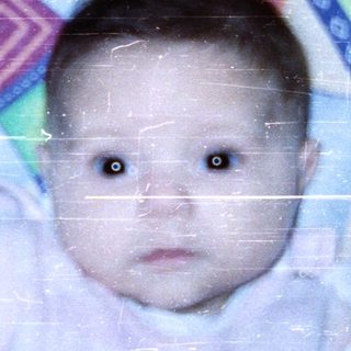 Baby in colorful play mat, reaching out.