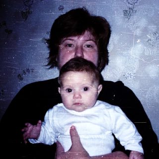 A woman holding a baby indoors.