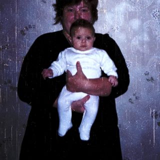 A woman holding a baby indoors.