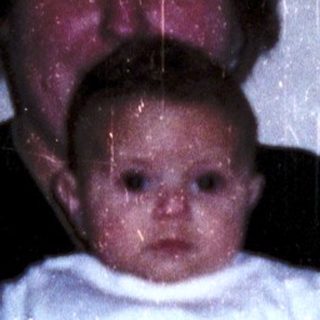 A woman holding a baby indoors.