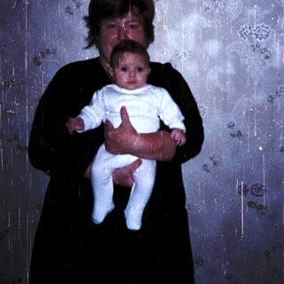 A woman holding a baby indoors.