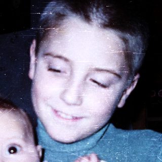 Young boy holding an infant indoors.