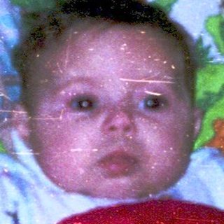 Baby in sleeper by snowy window.