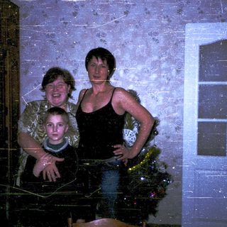 Family posing indoors near Christmas decorations.