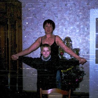 Two people posing indoors during heavy snowfall.
