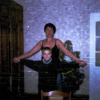 Two people posing indoors during heavy snowfall.