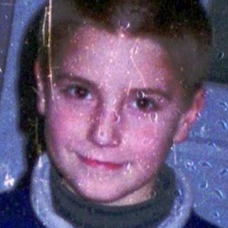 Boy holding toy gun at festive table.