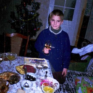 Boy holding toy gun at festive table.