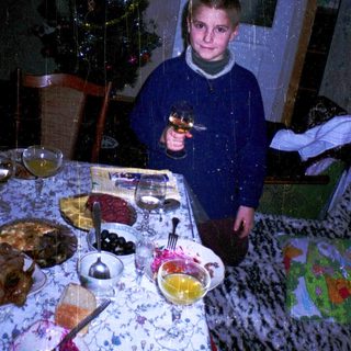 Boy holding toy gun at festive table.