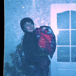 Child hugging stuffed animal during heavy snowfall.