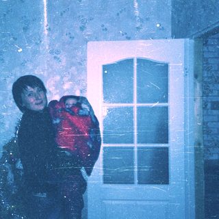 Child hugging stuffed animal during heavy snowfall.