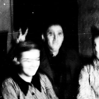 Three individuals posing indoors, mid-20th century.
