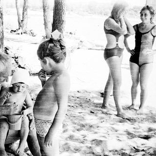 Family enjoying beach outing near water.