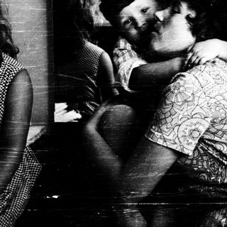 Tender embrace between two children indoors.