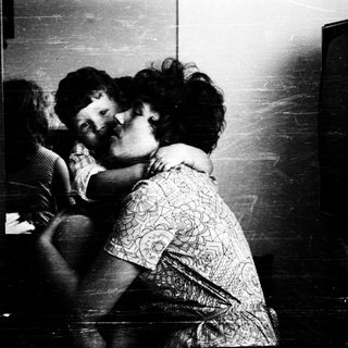 Tender embrace between two children indoors.