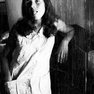 Young woman posing indoors with playful expression.