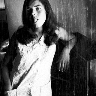Young woman posing indoors with playful expression.