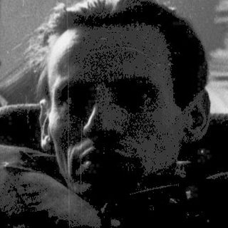 Man resting on bed near window with glass.
