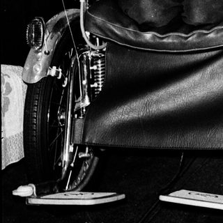 Man in wheelchair attached to motorcycle.