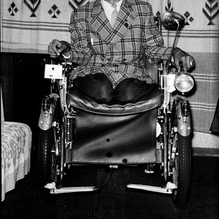 Man in wheelchair with motorcycle seat.