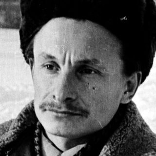 Man in winter attire posing outdoors in snowy setting.