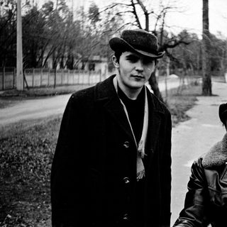 Two men posing outdoors in vintage winter attire.