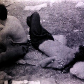 People lying on ground amid debris.
