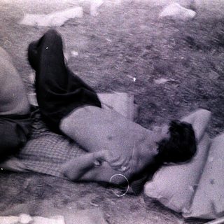 People lying on ground amid debris.