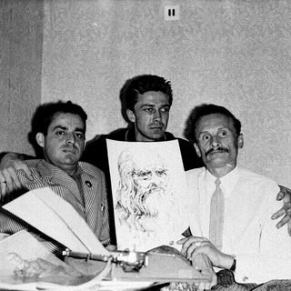Three men posing with abstract artwork, mid-20th century.