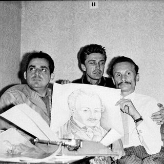 Three men holding a portrait of Lenin indoors.
